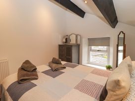 A bedroom with a bed and dresser at No.8 Millmoor Farm Cottage in Broad Haven