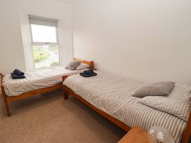 A bedroom with two single beds and a window at No.8 Millmoor Farm Cottage, Broad Haven