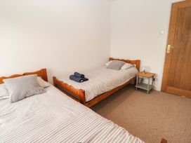 A bedroom with two beds and a side table at No.8 Millmoor Farm Cottage in Broad Haven