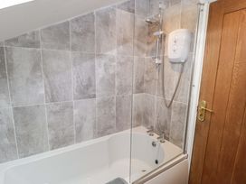 A bathroom with a bathtub and shower unit at No.8 Millmoor Farm Cottage Broad Haven