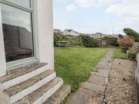 A garden with a bench and stone pathway at No.8 Millmoor Farm Cottage Broad Haven