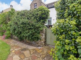 A garden pathway leading to a green gate at No.8 Millmoor Farm Cottage in Broad Haven