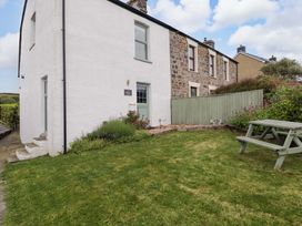 An outdoor view of a house with a garden at No.8 Millmoor Farm Cottage in Broad Haven