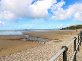 A beach with sand and sea under a cloudy sky at No.8 Millmoor Farm Cottage Broad Haven