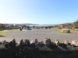 A parking lot with vehicles near the ocean at No.8 Millmoor Farm Cottage Broad Haven