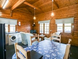 A living room with a table and chairs at Lodge 1 - Bron Eifion in Criccieth