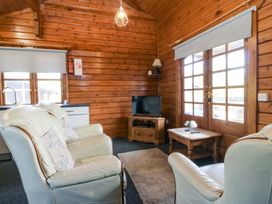 A living room with a television and sofa at Lodge 2 - Bron Eifion