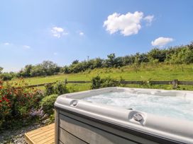A hot tub near greenery at The Three Spaniels Shepherds Hut Cwrtnewydd near Llanybydder
