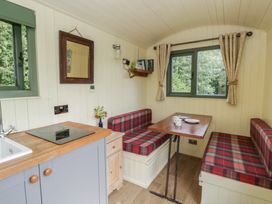 A dining area with a table and seating at The Three Spaniels Shepherds Hut in Cwrtnewydd near Llanybydder