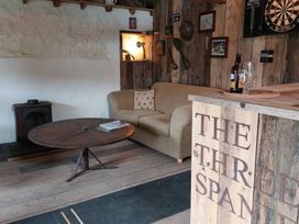 A snug with a sofa and a wood stove at The Three Spaniels Shepherds Hut in Lampeter