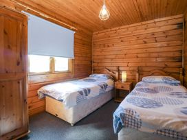 A bedroom with two beds and a window at Lodge 3 - Bron Eifion Criccieth