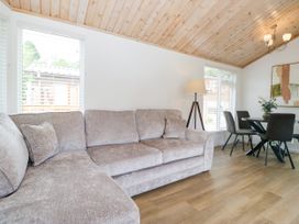 A living room with a sofa and dining area at Fox Red Retreat in Troutbeck Bridge