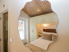 A bedroom with a bed and wardrobe at Fox Red Retreat in Troutbeck Bridge