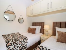 A bedroom with two beds and mirrors at Fox Red Retreat in Troutbeck Bridge