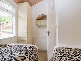 A bedroom with two beds and a wardrobe at Fox Red Retreat in Troutbeck Bridge