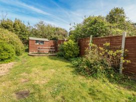 A garden with grass, a shed, and a picnic table at 12 West Street Weymouth