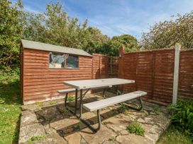 A garden with a table and benches near a shed at 12 West Street in Weymouth