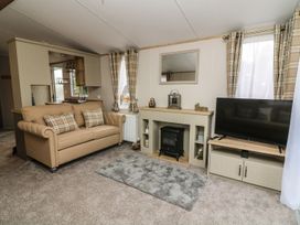 A living room with a sofa and television at Hedgehog Lodge in Carnforth