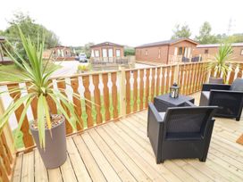 An outdoor area with chairs and a planter at Hedgehog Lodge Carnforth