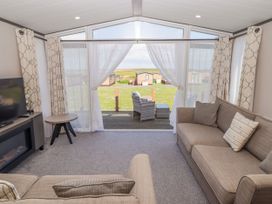 A living room with a sofa and television at Stone Crab Lodge in Haverfordwest