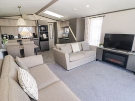 A living room with a sofa and television at Stone Crab Lodge in Haverfordwest