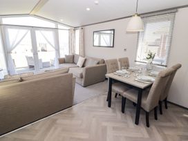 A living room with a sofa and dining area at Stone Crab Lodge in Haverfordwest