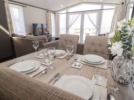 A dining room with a table set for a meal at Stone Crab Lodge in Haverfordwest