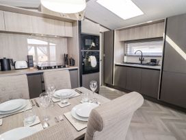 A kitchen with a dining table set for meals at Stone Crab Lodge in Haverfordwest