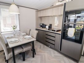 A kitchen with a dining area at Stone Crab Lodge in Haverfordwest