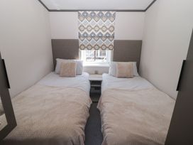 A bedroom with two beds and a window at Stone Crab Lodge in Haverfordwest