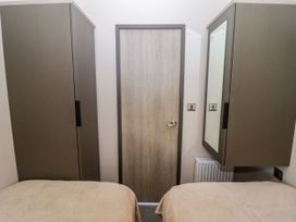 A bedroom with wardrobes and a door at Stone Crab Lodge in Haverfordwest