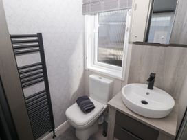A bathroom with a toilet and sink at Stone Crab Lodge in Haverfordwest