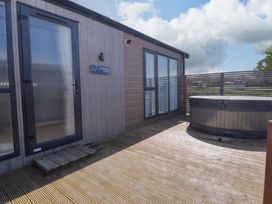 An outdoor area with a hot tub and entrance at Stone Crab Lodge in Haverfordwest