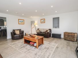A living room with a coffee table and two armchairs at Ty Hebog