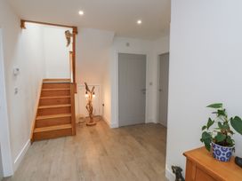 A hallway with a staircase and wooden furniture at Ty Hebog