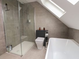 A bathroom with shower, bathtub and toilet at Ty Hebog