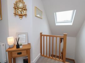 A stairway with a clock and a lamp at Ty Hebog in 