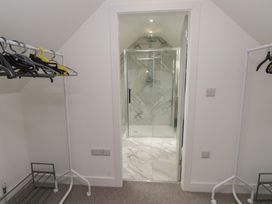 A bathroom with a shower and clothes hangers at Ty Hebog in 