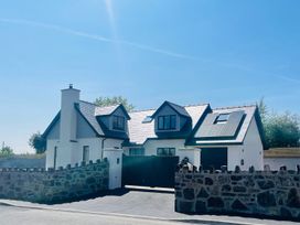 A house with a stone wall and gate at Ty Hebog Beaumaris