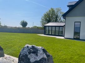 A garden with a house and grass at Ty Hebog Beaumaris