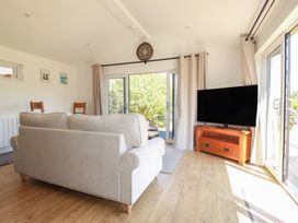 A living room with a sofa and television at Wisteria Lodge in Redruth