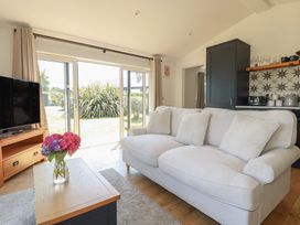 A living room with a sofa and television at Wisteria Lodge in Redruth