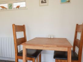 A dining room with a table and chairs at Wisteria Lodge Redruth