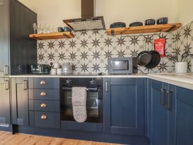 A kitchen with oven and microwave at Wisteria Lodge in Redruth