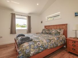 A bedroom with a bed and bedside table at Wisteria Lodge in Redruth