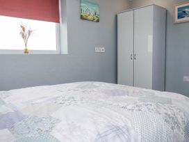 A bedroom with a bed and wardrobe at Likely Sunset in St. Austell