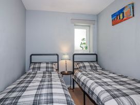 A bedroom with two beds and a lamp at Likely Sunset in St. Austell