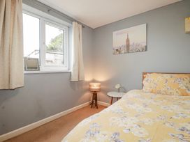 A bedroom with a bed and lamp at Likely Sunset in St. Austell