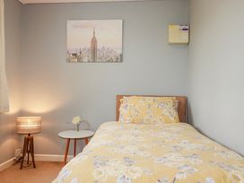 A bedroom with a bed and nightstand at Likely Sunset in St. Austell