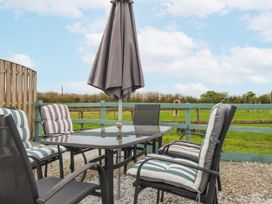 An outdoor seating area with a table and chairs at Likely Sunset in St. Austell